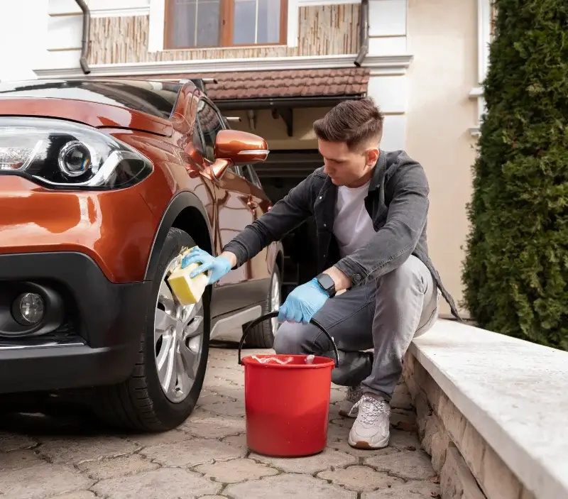 Lavage auto à domicile Le Coudray-Montceaux : professionnel intervenant sur un véhicule